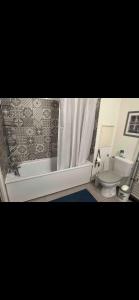 a bathroom with a tub and a toilet and a shower at Appartement 4 personnes idéal JO 2024 in Tremblay En France