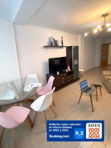 a living room with a table and chairs and a tv at A las puertas de la Catedral 90m2 con Garaje in Vitoria-Gasteiz