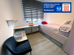 una piccola camera con letto e scrivania di A las puertas de la Catedral 90m2 con Garaje a Vitoria-Gasteiz