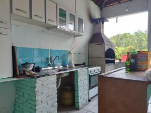 a kitchen with a stove and an outdoor oven at Chácara Boa Esperança in Franco da Rocha
