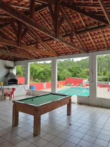 a pool table in the middle of a room with a swimming pool at Chácara Boa Esperança in Franco da Rocha