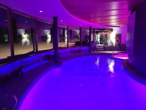 a swimming pool in a house with purple lights at Roundhouse Grotto in Calgary