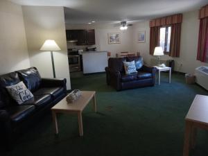 ein Wohnzimmer mit 2 Ledersofas und einem Tisch in der Unterkunft Paradise Shores Hotel in Holcombe