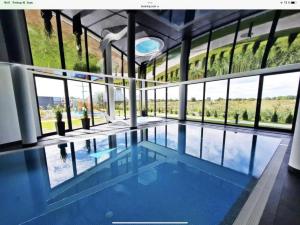 - une piscine dans un bâtiment doté de grandes fenêtres dans l'établissement Westin House-Resort, à Kołobrzeg