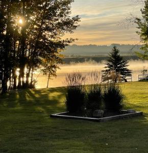 a field with trees and a body of water at Roundhouse Grotto in Calgary