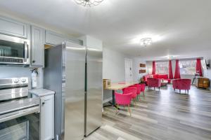 cocina con nevera y mesa con sillas rojas en Comfy Kingsport Apartment - Walk to Brewery!, en Kingsport