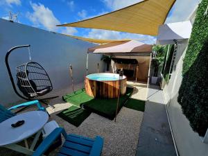 un patio con vasca idromassaggio, tavolo e sedie. di Astrolax Cinema with Jacuzzi & 4D Massage Chair a Ponce