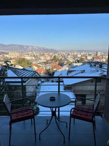- Balcón con vistas, mesa y 2 sillas en Modern Apartment with Panoramic City Views, en Skopje