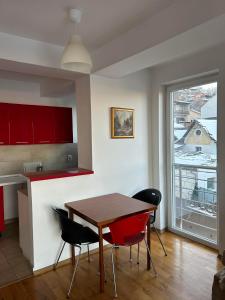 cocina con mesa, sillas y ventana en Modern Apartment with Panoramic City Views, en Skopje