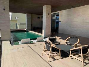 a patio with a table and chairs next to a pool at Ocean View Condo in Mazatlán