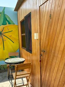 Paracas Camp Lodge & Experiences في باراكاس: باب إلى منزل صغير مع طاولة وكرسي