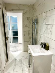 a white bathroom with a sink and a shower at Swanmore in Derby