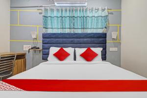 a bedroom with a bed with red and blue pillows at OYO Flagship Luxury Rooms in Hyderabad
