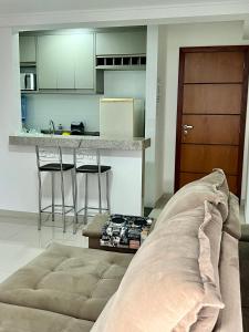 ein Wohnzimmer mit einem Sofa vor einer Küche in der Unterkunft Lindo apartamento 1 quarto próximo a Rua de Lazer Domingos Martins in Domingos Martins