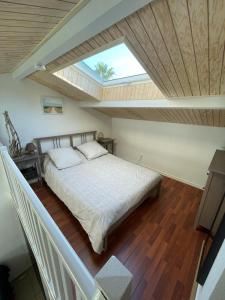 ein Schlafzimmer mit einem großen Bett mit Dachfenster in der Unterkunft Studio Mezzanine Piscine presqu'île de Giens in Hyères + 30 Fotos