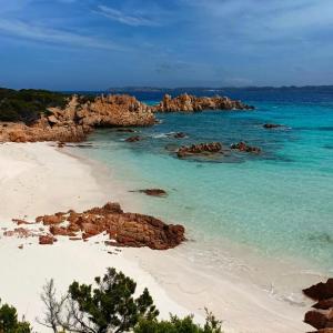 - une plage avec des rochers dans l'eau et l'océan dans l'établissement DomoMea - L'Isola nell'Isola - R3442, à La Maddalena