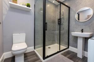 a bathroom with a shower and a toilet and a sink at Beachfront Apartment 3 Bedrooms Sleeps 7 - Newly Refurbished in Morecambe