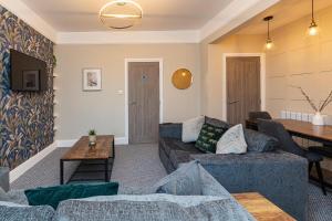 a living room with two couches and a table at Beachfront Apartment 3 Bedrooms Sleeps 7 - Newly Refurbished in Morecambe