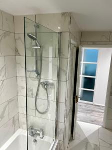 a bathroom with a shower and a tub and a sink at Swanmore in Derby