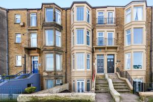 an apartment building with stairs in front of it at Beachfront Apartment 3 Bedrooms Sleeps 7 - Newly Refurbished in Morecambe