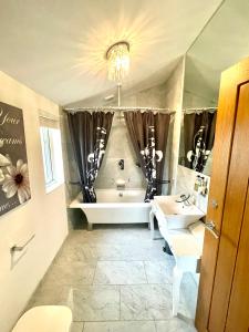 y baño con bañera, aseo y lavamanos. en The Applewood Lodge en Heytesbury