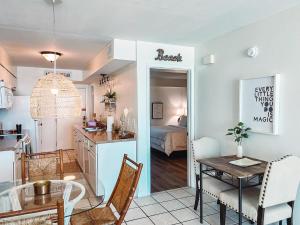 a kitchen and living room with a table and a dining room at Little Miss Magic in Gulf Shores
