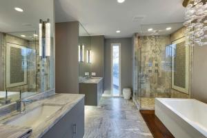 bagno con 2 lavandini, vasca e doccia di Linden Hills Designer Retreat a Minneapolis
