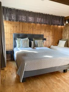 a bedroom with two beds and a wooden wall at Haukaberg House in Höfn