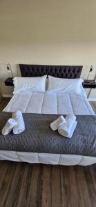 een bed met twee paar slippers erop bij Departamentos del oeste in Bariloche