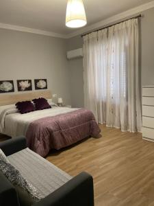 a bedroom with a bed and a couch and a window at Apartamento Venus in Salar