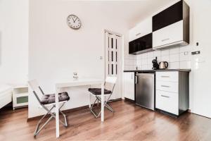 eine Küche mit einem Schreibtisch sowie einem Tisch und Stühlen in der Unterkunft Top floor sunny studio with terrace in Prag
