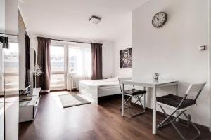 Schlafzimmer mit einem Bett, einem Schreibtisch und einem Tisch in der Unterkunft Top floor sunny studio with terrace in Prag