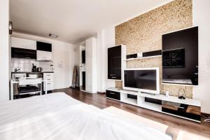 ein Wohnzimmer mit einem Bett und einem großen TV in der Unterkunft Top floor sunny studio with terrace in Prag