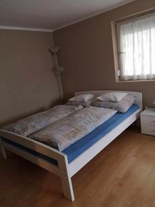 a large bed in a bedroom with a window at Kiss Apartman in Balatonboglár