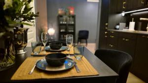 una mesa con dos platos y copas de vino. en Moderne cityleilighet Sogndal en Sogndal