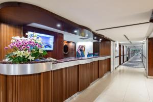 a lobby with a bar with flowers on it at Mena Hotel Nasiriah Riyadh in Riyadh