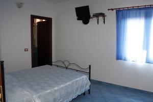 ein Schlafzimmer mit einem Bett und einem TV an der Wand in der Unterkunft HOTEL SANTA CLARA in Camerota