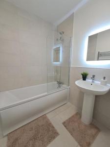 La salle de bains blanche est pourvue d'un lavabo et d'une douche. dans l'établissement Cozy bedroom in Lucan, Dublin, à Dublin