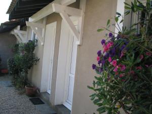 a white door with flowers on the side of a building at Appartements Les Déferlantes Mimizan-plage in Mimizan-Plage