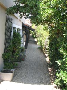 a walkway next to a building with some plants at Appartements Les Déferlantes Mimizan-plage in Mimizan-Plage