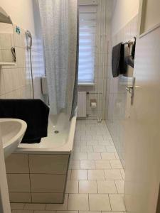 ein weißes Bad mit einem Waschbecken und einer Dusche in der Unterkunft Choice Berlin - Wohnung für bis zu 12 Personen in Berlin