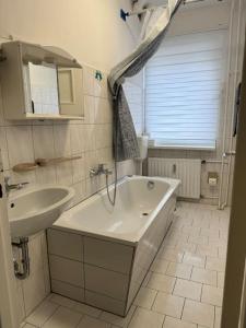 ein Badezimmer mit einer weißen Badewanne und einem Waschbecken in der Unterkunft Choice Berlin - Wohnung für bis zu 12 Personen in Berlin