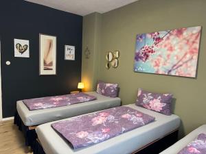 2 Betten in einem Zimmer mit lila und rosa Bettwäsche in der Unterkunft Choice Berlin - Wohnung für bis zu 12 Personen in Berlin