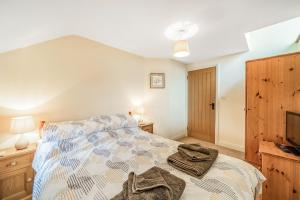 a bedroom with a bed with a comforter on it at Greystones in Milnthorpe