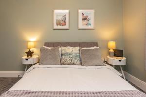 Stylish Seafront 2 Bedroom Apartment - Brand New في موركامب: غرفة نوم بسرير كبير فيها مصباحين