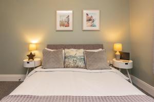 a bedroom with a large bed with two lamps at Stylish Seafront Apartment - Sleeps 6 - Gateway to the Lakes in Morecambe