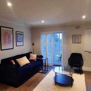 uma sala de estar com um sofá preto e uma mesa de vidro em Faithlegg Mews em Waterford