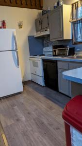 a kitchen with a white refrigerator and a stove at Oceans - KING BED Cabin Loft & Fireplace in Tobyhanna