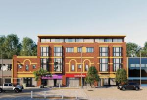 a brick building with cars parked in a parking lot at Hemel Hives in Hemel Hempstead