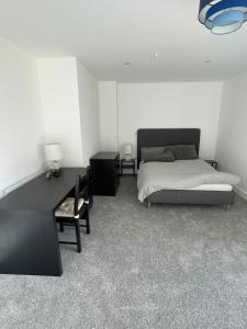 a bedroom with a bed and a table and a chair at Hemel Hives in Hemel Hempstead